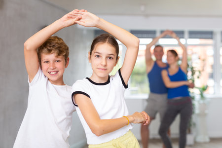 Boy and girl dancing salsa in studio during group trainingの写真素材