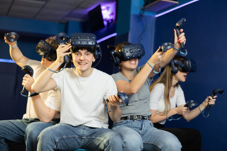 Excited young guy in VR glasses playing virtual reality gameの写真素材