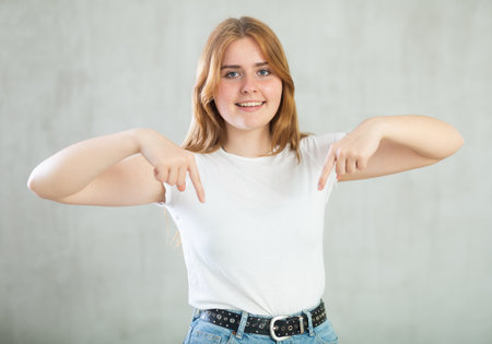 Excited girl holding palm open for new product or sale presentation.の写真素材