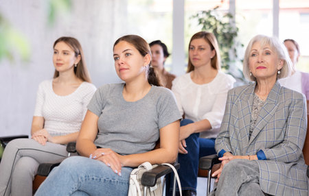 Young positive woman listening to lecture in office