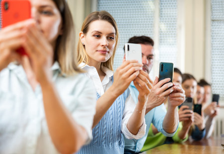 Group of students taking pictures with smartphonesの写真素材