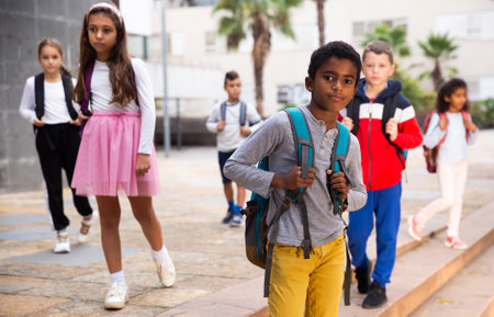 African american boy standing near school, children on backgroundの写真素材