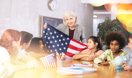 Friendly female teacher tells the pupils the history of the USA