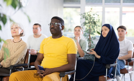 Focused African American man listening to lecture in group auditorium