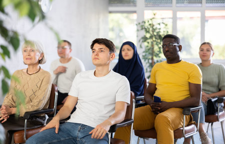 Focused young guy listening to lecture in group auditoriumの写真素材