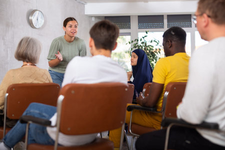 Young positive woman giving lecture in office
