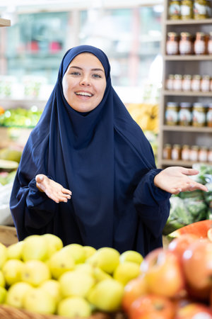 Young european woman in muslim dress standing at local marketの写真素材