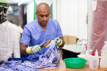 Skilled man working in dry cleanerの写真素材