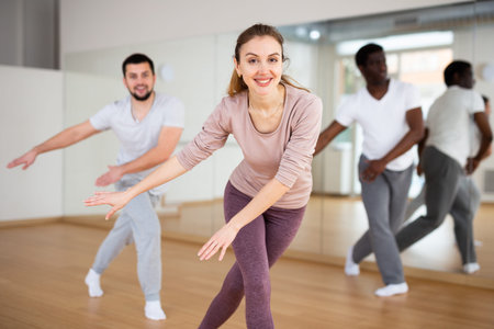 Woman dancing aerobic dance with men in studio