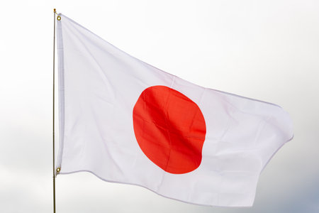 Flag of Japan flying against blue skyの写真素材