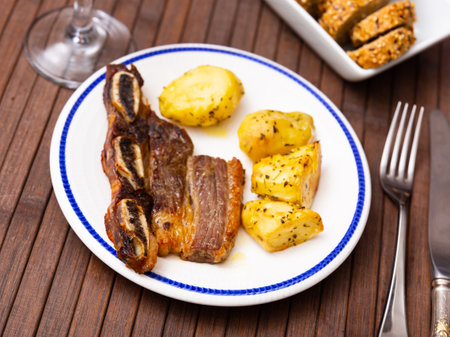 Grilled beef spare ribs with baked potatoes and greensの写真素材