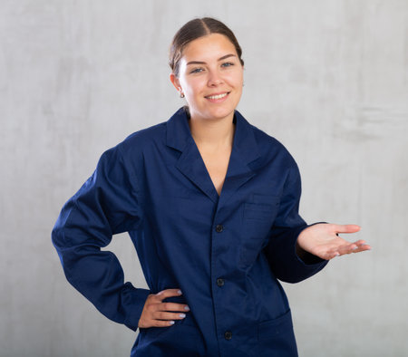 Portrait of emotional storekeeper woman in uniform on gray backgroundの写真素材