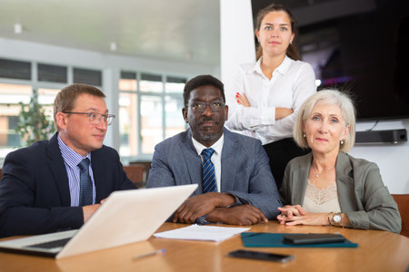Group of different people posing at table in officeの写真素材