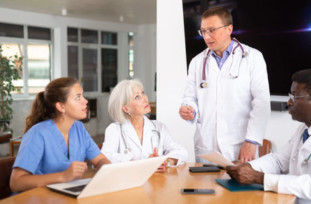 Group of different people medics having discussion at table