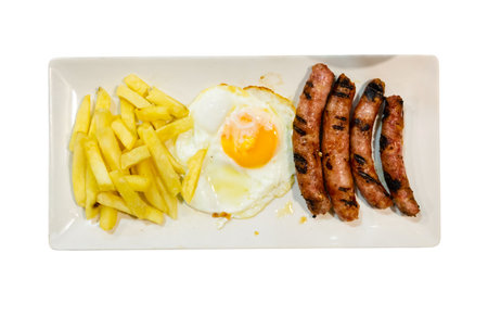 Dish of four grilled sausages with eggs and French friesの写真素材