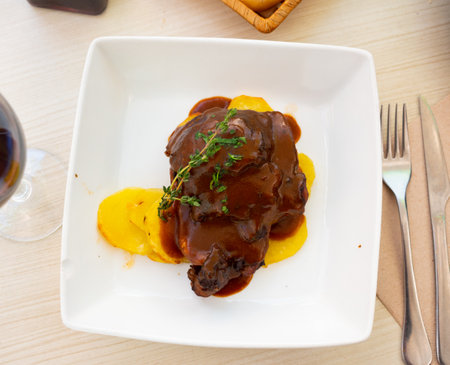 Pork chop in wine sauce with sliced potato served in a plateの写真素材