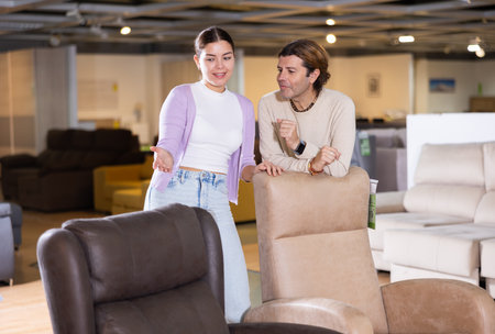 Man and woman looking to buy armchair in furniture storeの写真素材