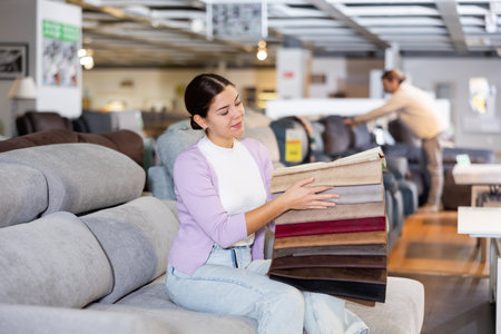 Woman picking upholstery material in furniture store