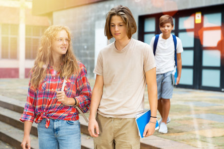 Boy and girl walking home after finishing lessonsの写真素材
