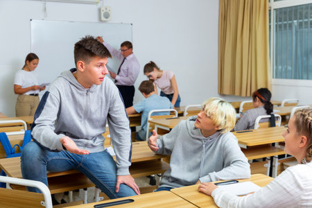 Teenage students talking during recess between lessonsの写真素材