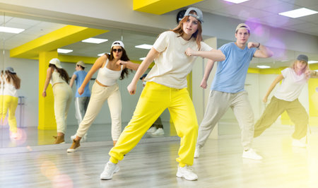 Young girl in cap training breakdance Toprock moves in dance hallの写真素材