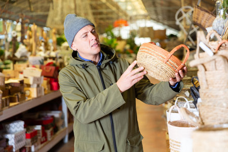 Portrait of man searching wicker basket for storageの写真素材