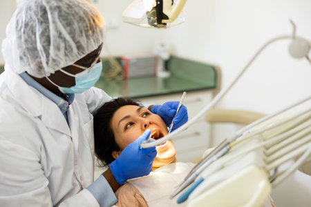 Closeup view of dentist treating teeth of woman in dentist officeの写真素材