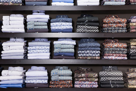 Men shirts displayed on shelves in shopの写真素材