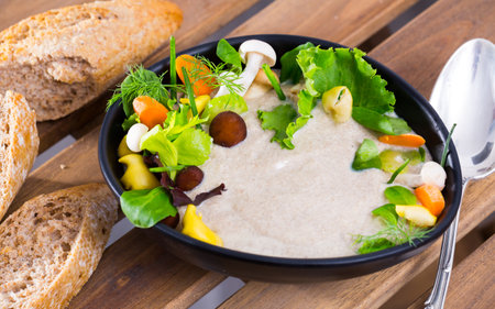 Cream soup with shitake mushroom served with vegetables and greensの写真素材