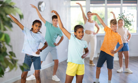 African girl perform social dance vogue with friends and female teacher in background