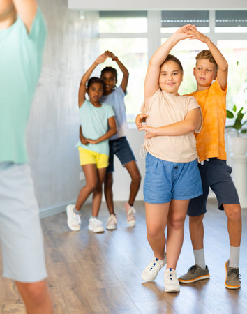 Active preteen children practicing Ballroom dances in pairs in training hallの写真素材