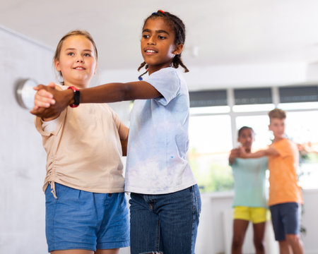 Multinational boys and girls enjoying active dance in studioの写真素材