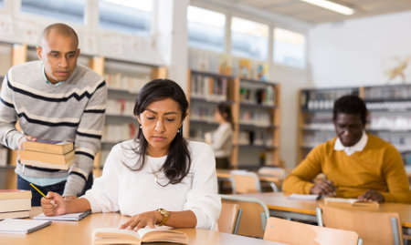 Young adult woman studying in public libraryの写真素材