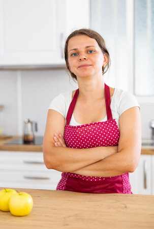 Young woman in apron posing in kitchenの写真素材