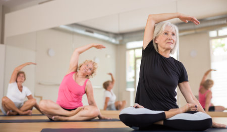 Group of mature women exercising in lotus poseの写真素材
