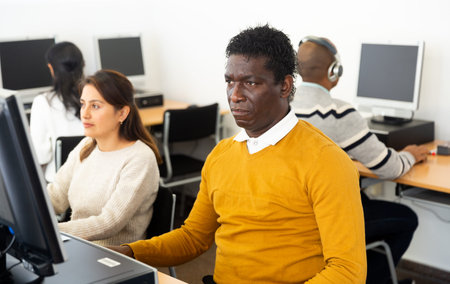 Young adult man studying in computer class