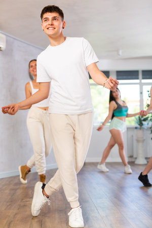 Portrait of boys and girls training hip hop movements during group class in studio