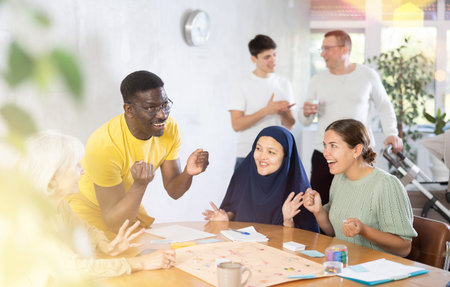 Group of multinational people playing board game