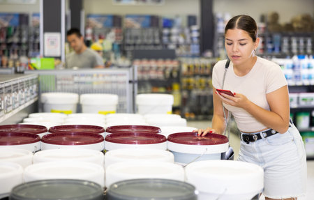 Female shopper scanning a QR code using a mobile phone in hardware store
