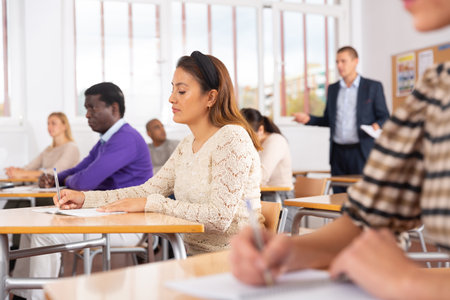 Focused hispanic woman on lesson in school auditoriumの写真素材