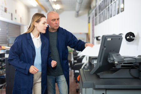 Man and woman working in printshopの写真素材