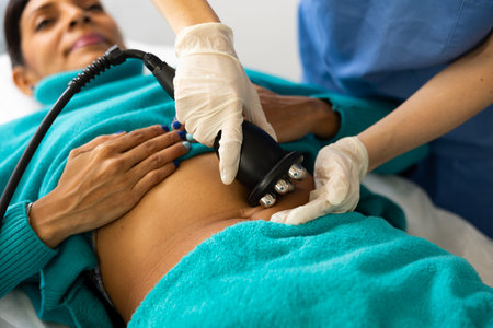 Woman receiving radio frequency abdomen lifting procedure