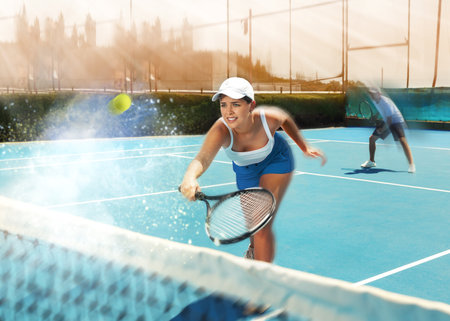 Woman playing tennis on court. Racket sport training outdoorsの写真素材