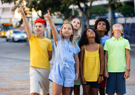 Interested multiracial children pointing fingers and looking upの写真素材