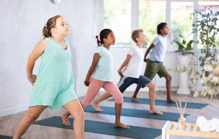 Children doing stretching workout for body flexibility in yoga studioの写真素材