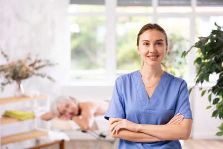 Successful confident young female massage therapist standing in procedure roomの写真素材
