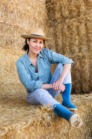 Woman posing at hay storage on farmの写真素材