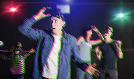 Portrait of a surprised young man who took off his virtual reality glasses