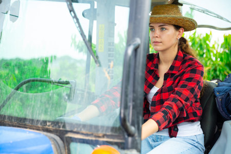 Girl farmer working on a tractor at a orchardの写真素材