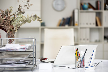 Modern workplace with laptop and telephone, stylish organizers with stationery in light office. Workspace ergonomics conceptの写真素材